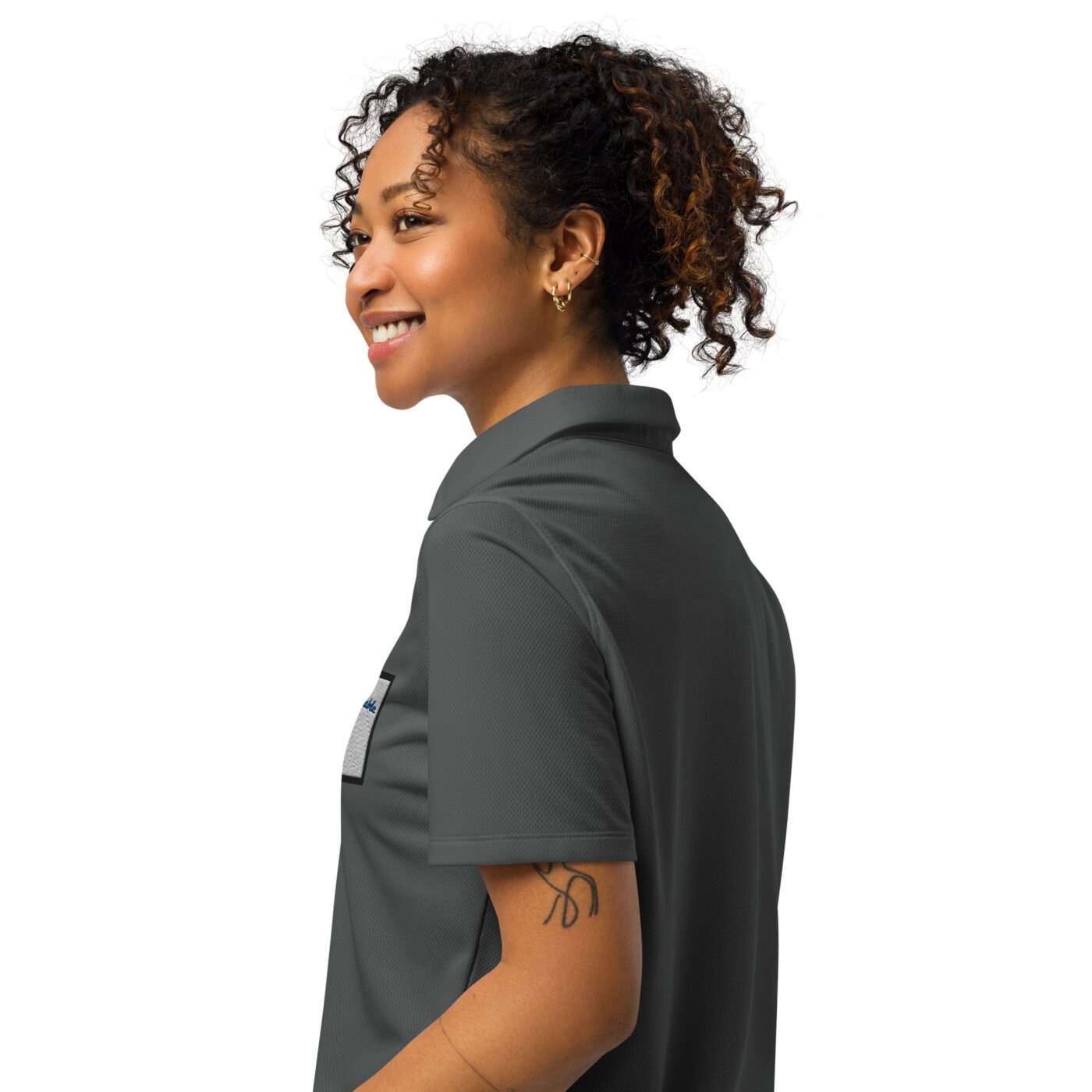 A woman with curly hair wearing a gray shirt.