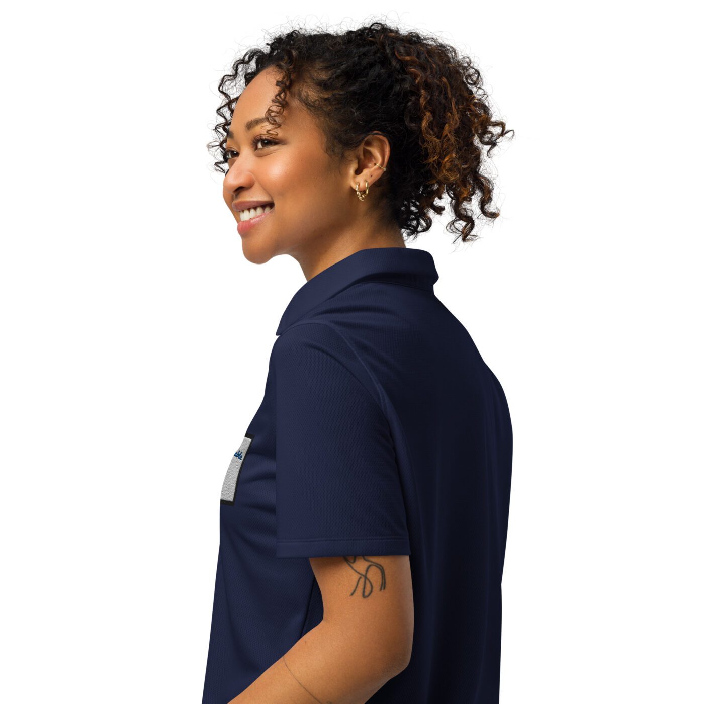 A woman with curly hair wearing a blue shirt.