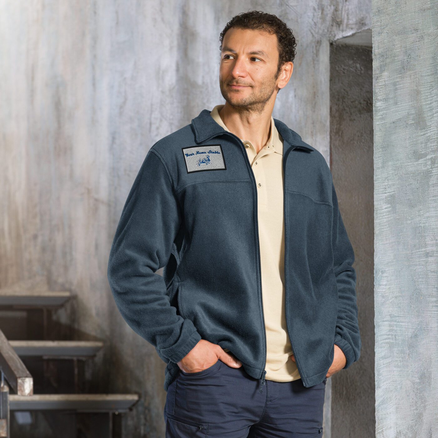 A man standing in front of some steps wearing a blue jacket.