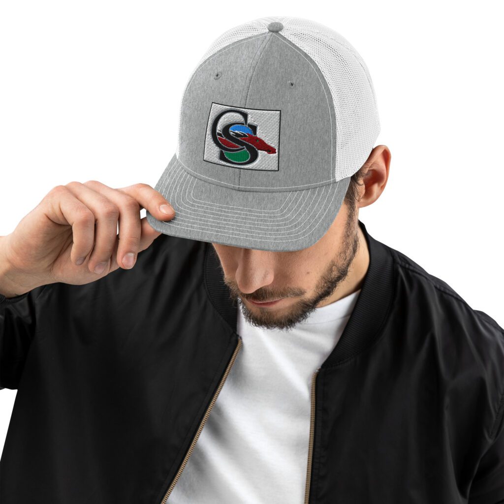 A man in a white shirt and black jacket holding his hat